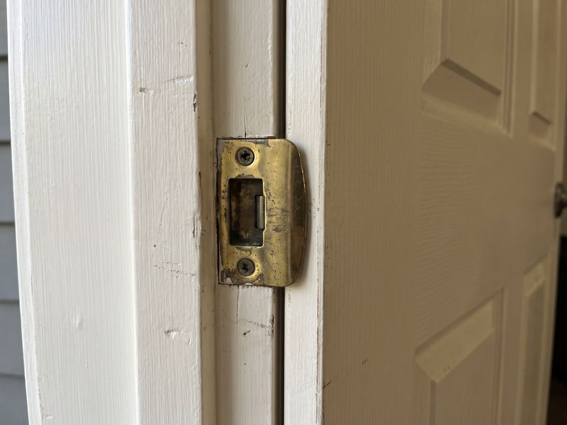 A strike plate and latch on an interior door frame, the door closed square